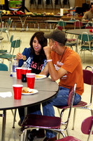 A Couple Sitting At A Table Eating