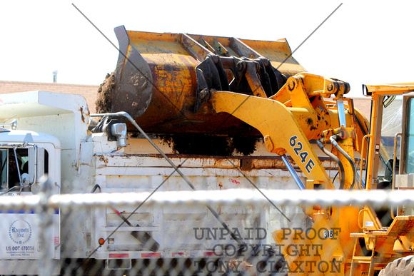 Front End Loader Dumping Soil Into A Dump Truck