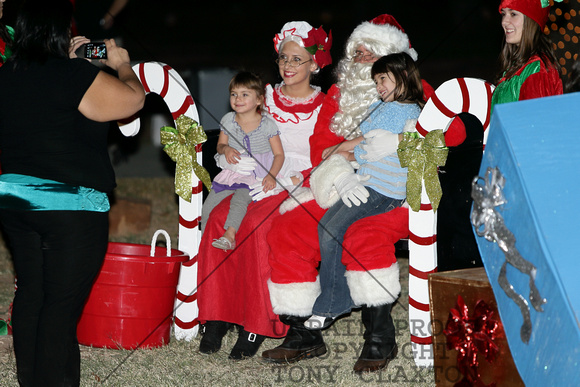 Santa And Mrs. Claus And An Elf Have Their Picture Taken With Two Children