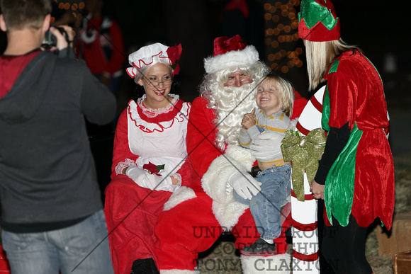 Santa And Mrs. Claus Pose With A Child