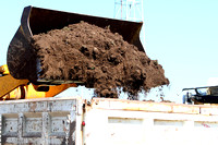 Front End Loader Dumping Soil Into A Dump Truck