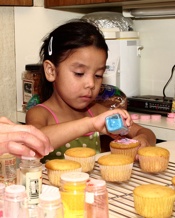 Kaylee Sprinkling Decorations On A Cupcake