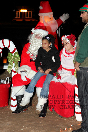 Santa And Mrs. Claus Posing With A Child